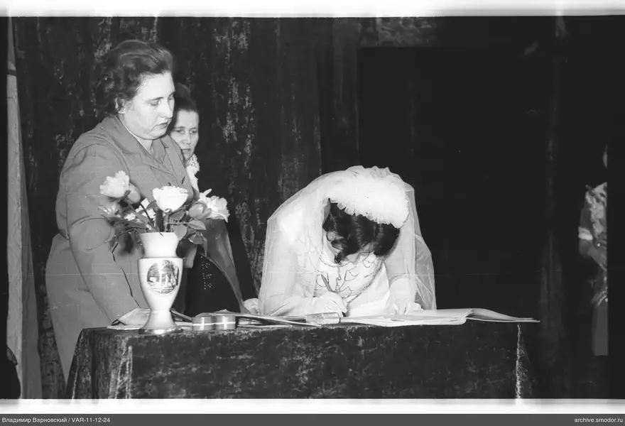 Woman in wedding dress signing a document