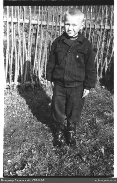 Junge in dunkler Jacke und Stiefeln