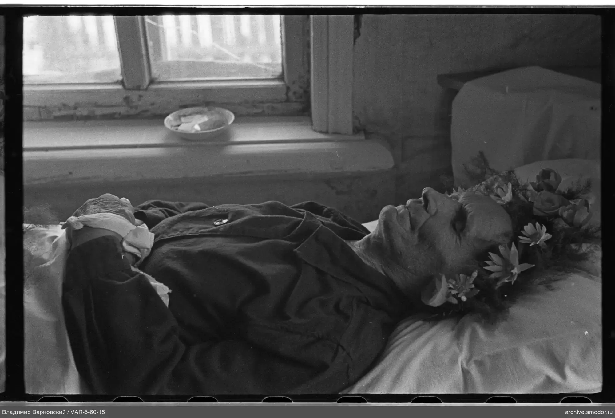 Person mit Blumenkranz auf Bett
