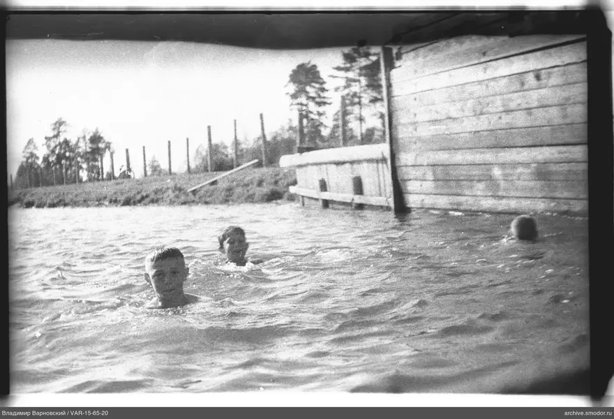 Drei Jungen im Wasser bei einem Steg