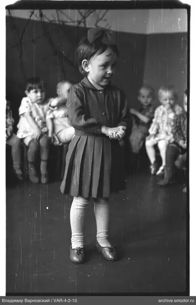 Mädchen mit Schleife und Kinder im Hintergrund