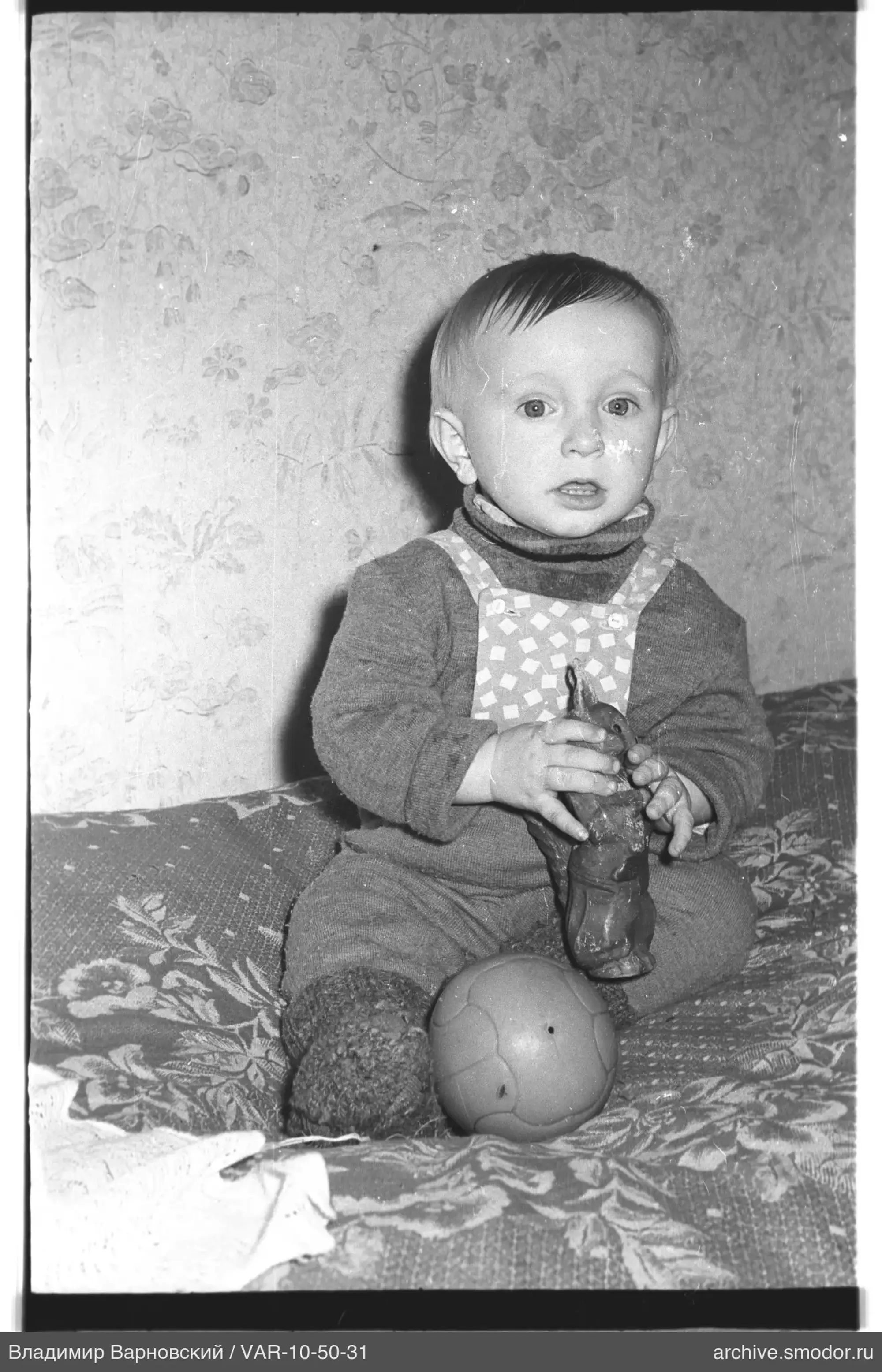 Ребёнок с фигуркой животного на диване