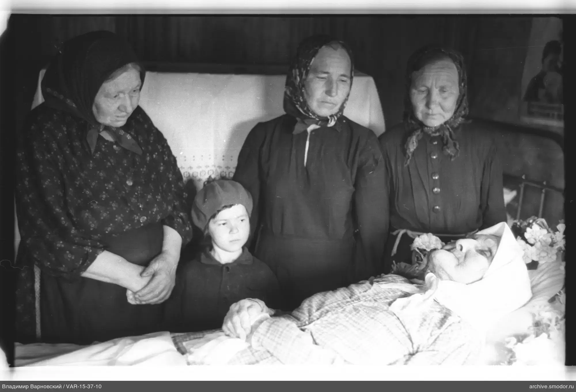 Gruppe von Frauen bei einem Bett mit älterer Frau