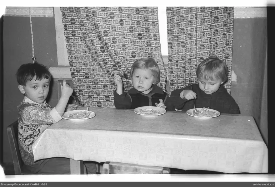 Three children at a table with food