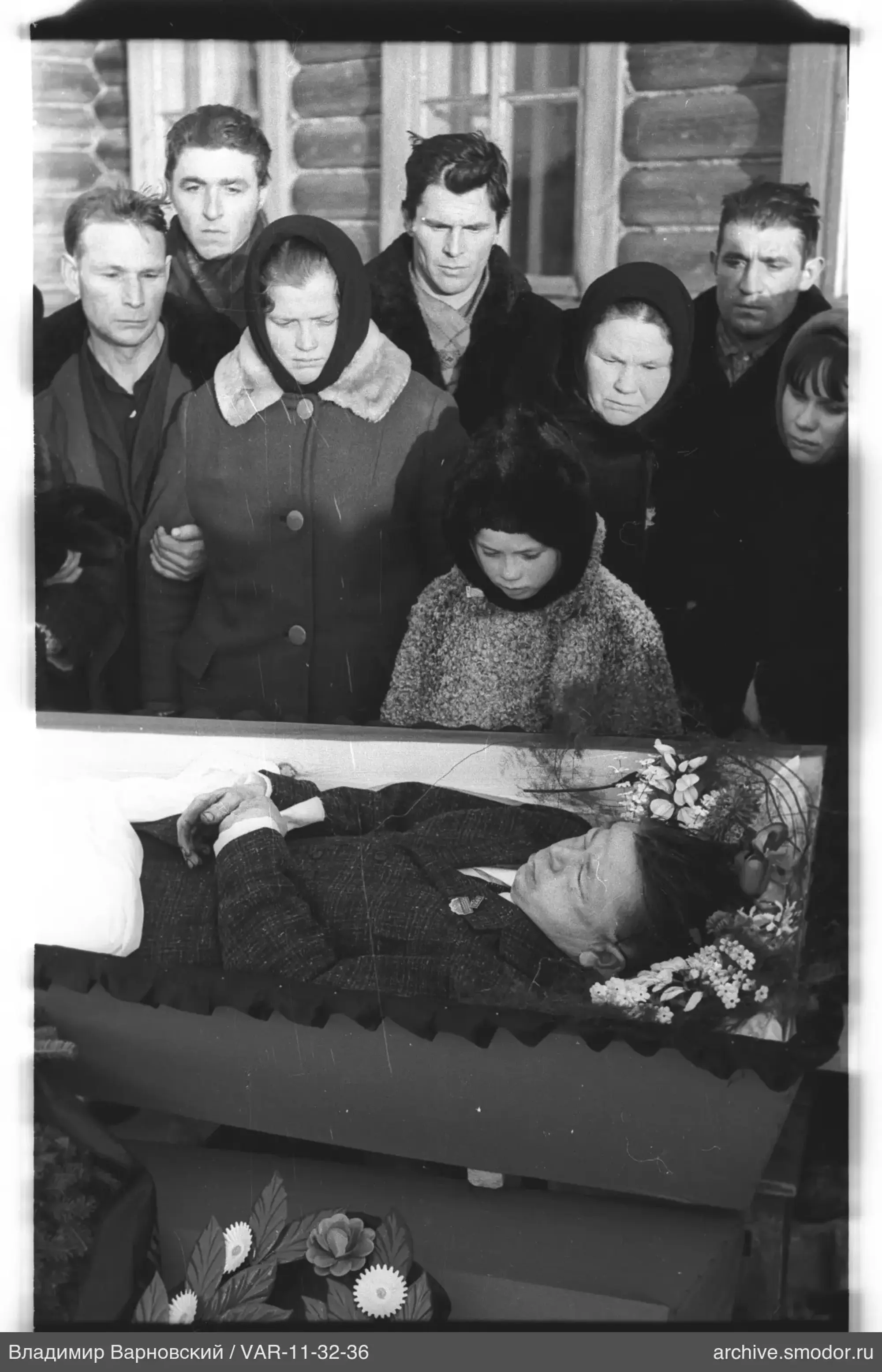 Group at coffin with man's body
