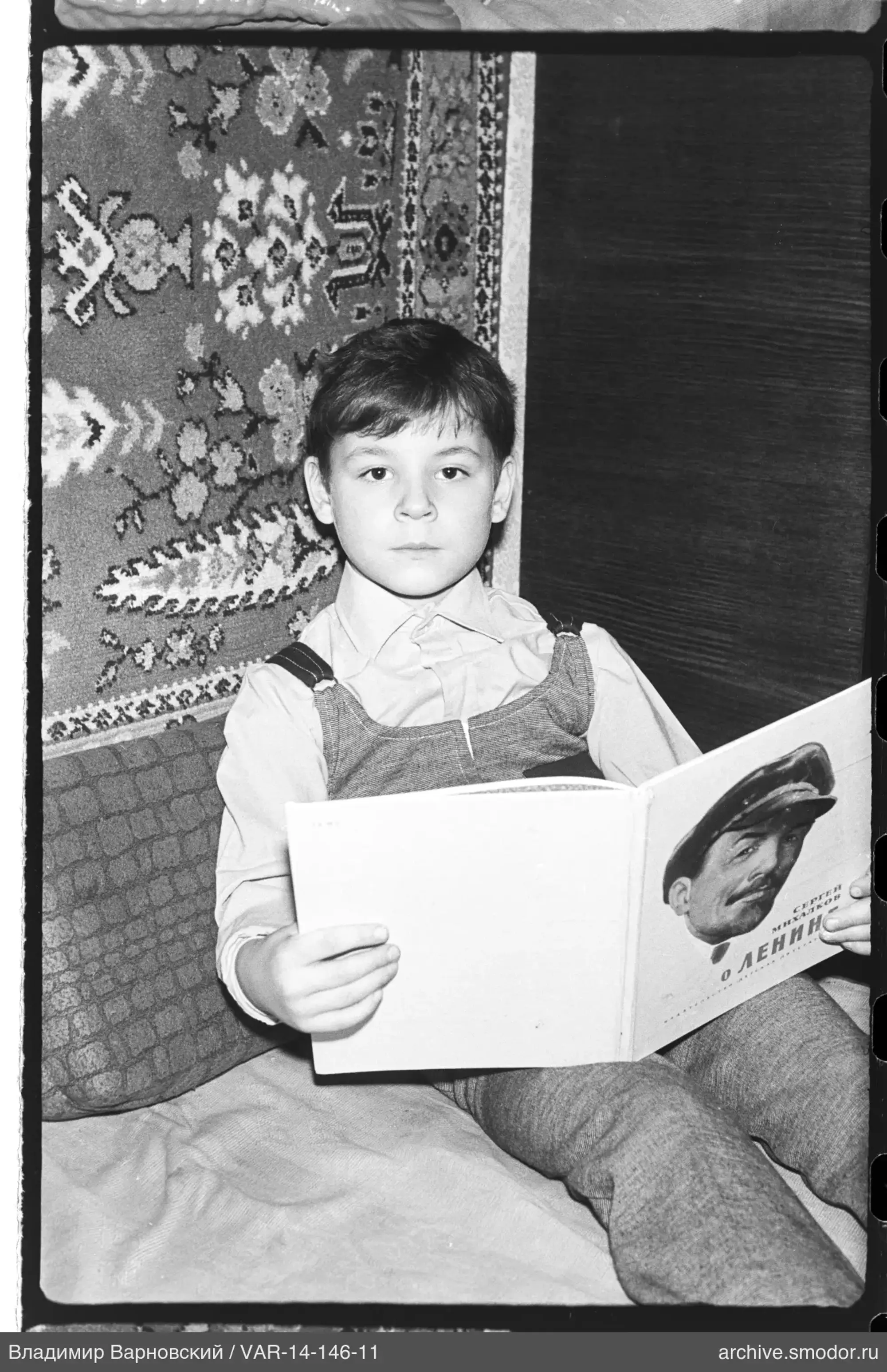 Boy with a book on the bed
