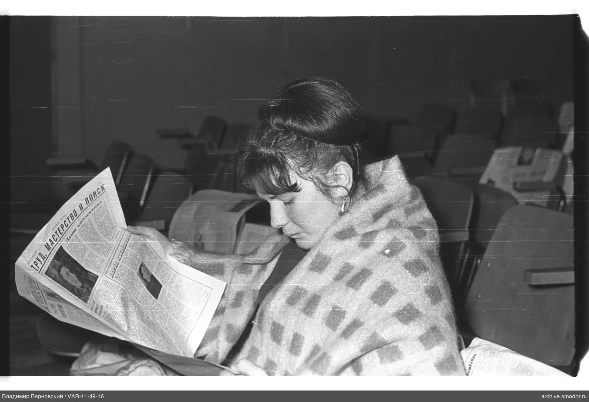Woman in armchair with newspaper