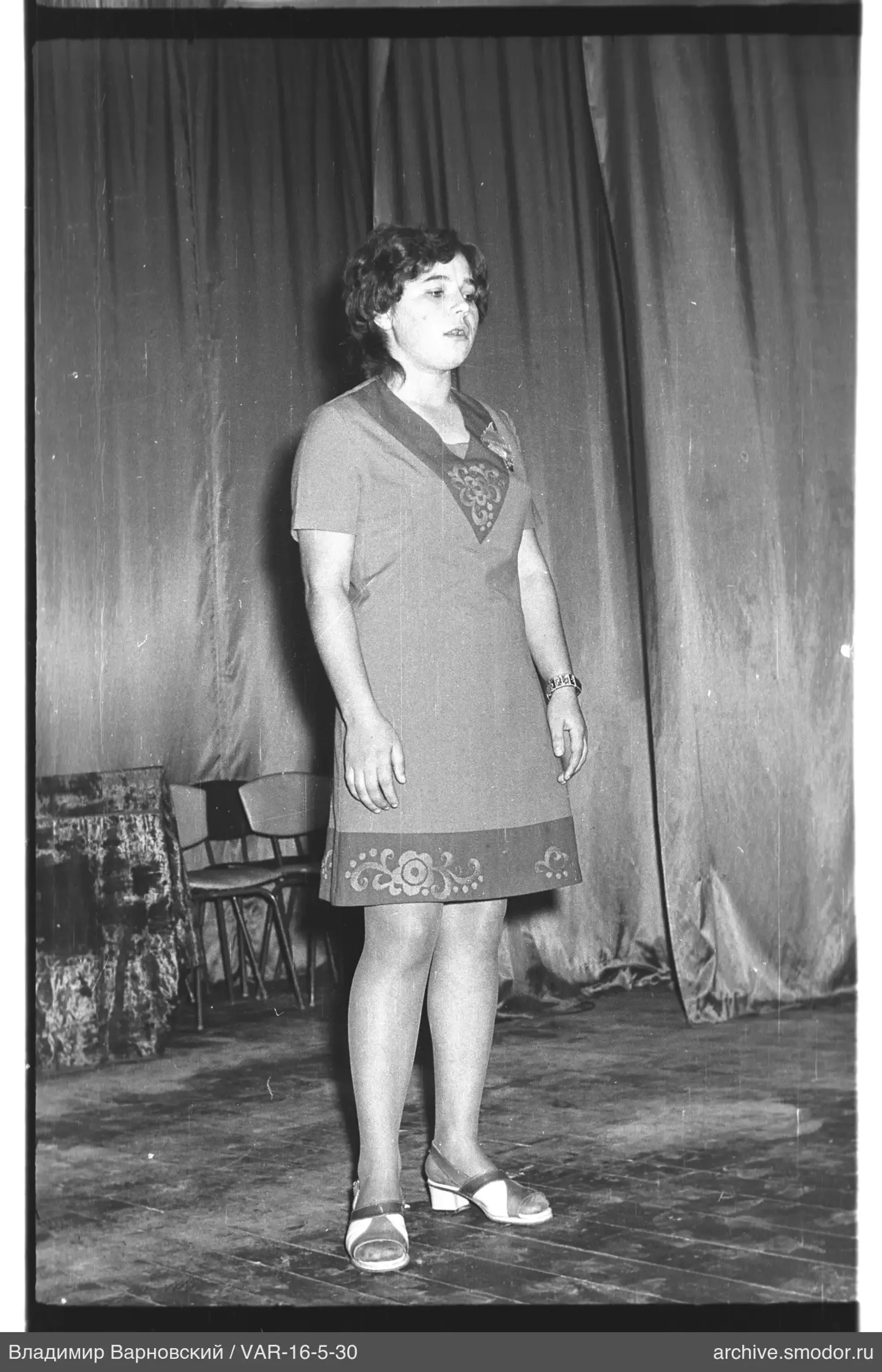 Frau in kurzem Kleid vor Vorhang