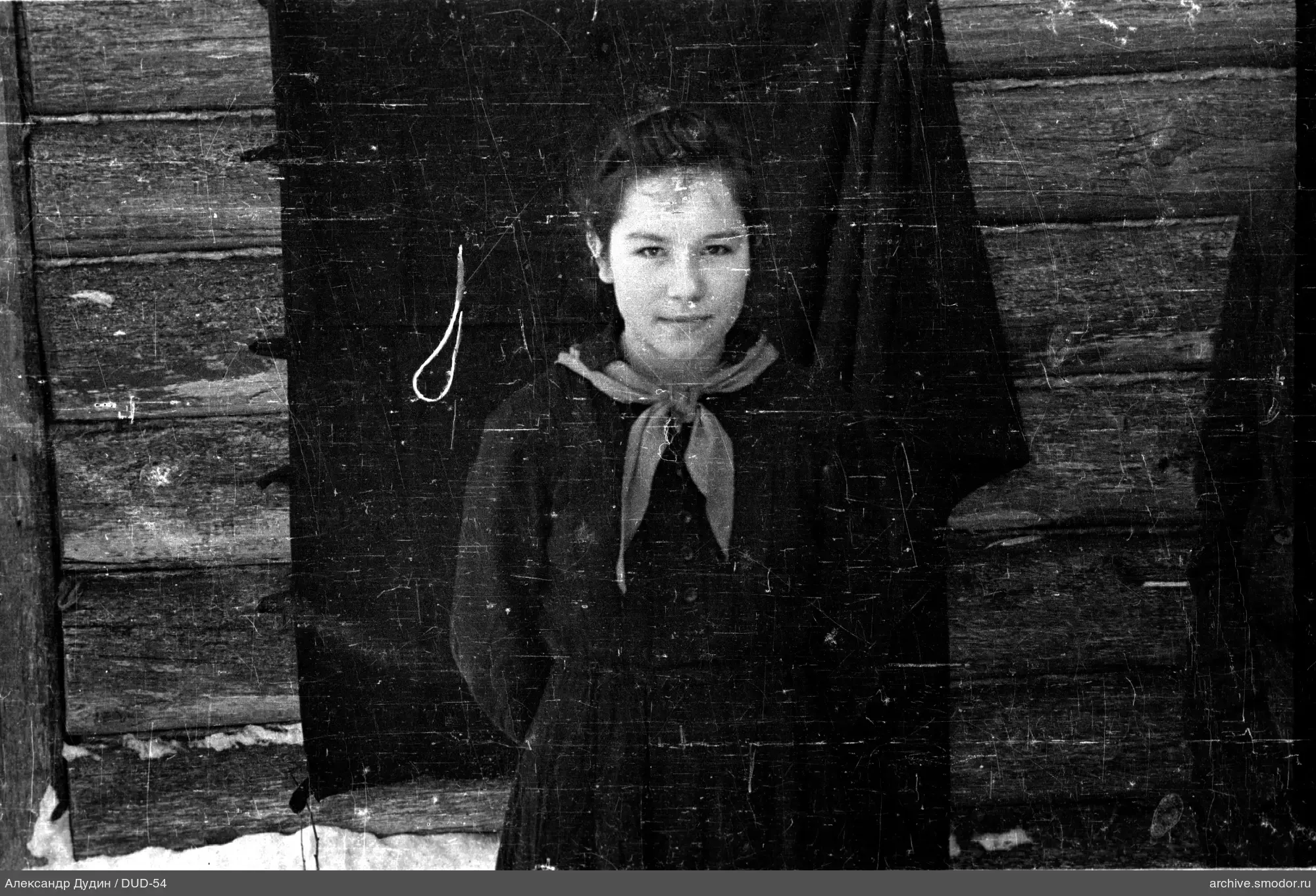 Mädchen im Schnee an Holzwand