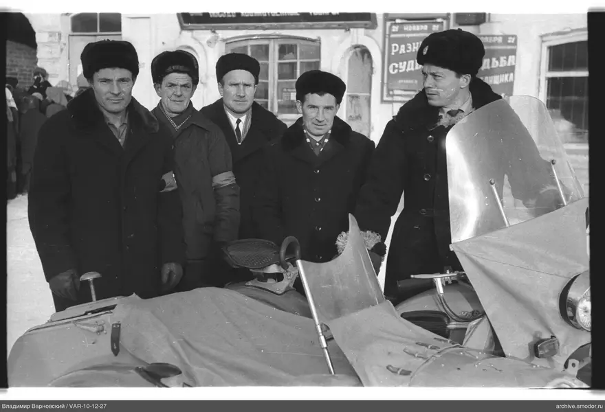 Группа мужчин с мотоциклом и шапками-ушанками