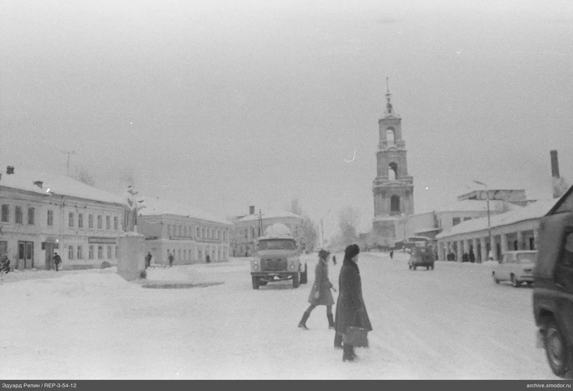 Городская улица зимой с памятником и колокольней