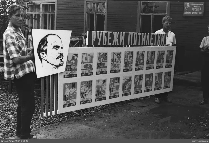 Gruppe von Männern mit Plakat vor Holzgebäude