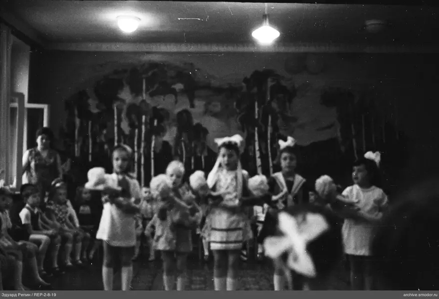 Kinder mit Schleifen und Pompons im Raum mit Birkenwald