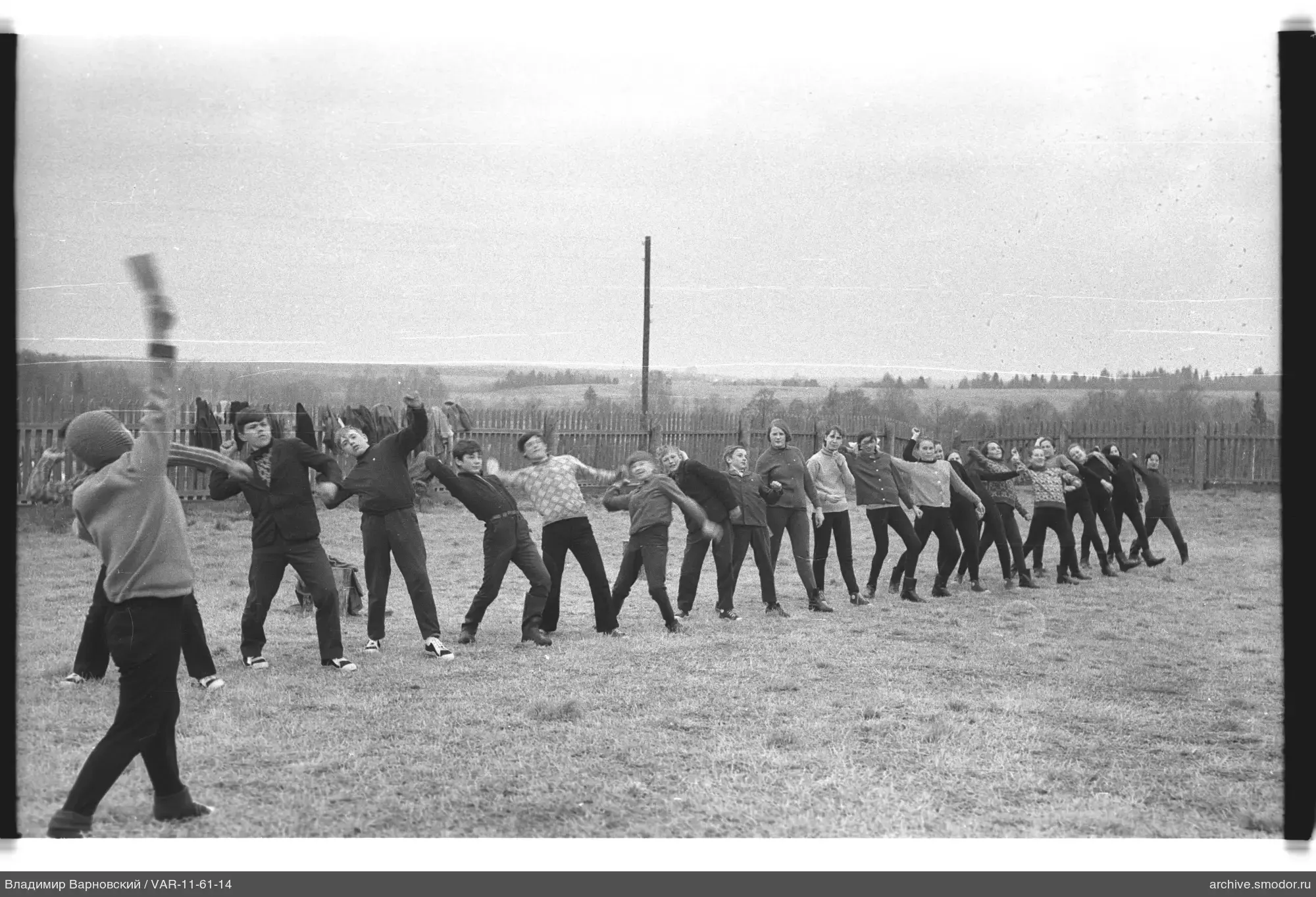 Gruppe von Menschen im Feld mit erhobenen Händen