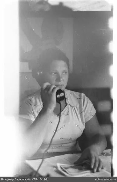 Frau mit Telefon am Tisch