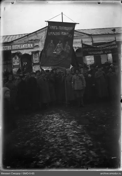 Группа людей перед зданием с вывеской
