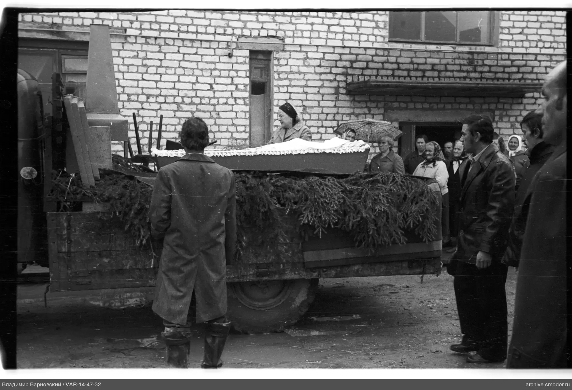Gruppe neben Lastwagen mit Sarg
