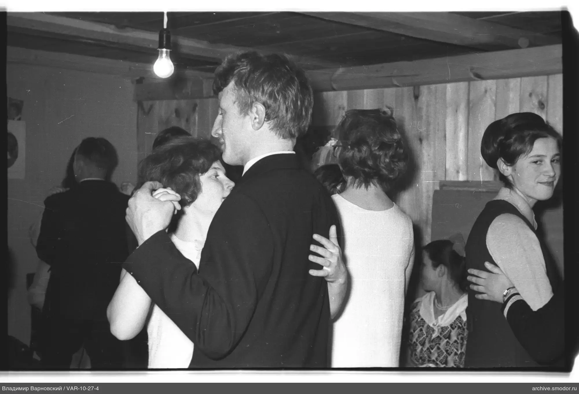 People dancing in a wooden-walled room