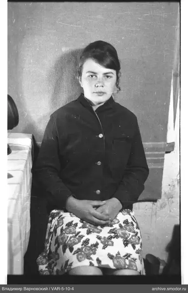 Portrait of a seated woman in a floral skirt