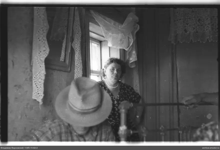 Frau am Fenster und Mann im Raum