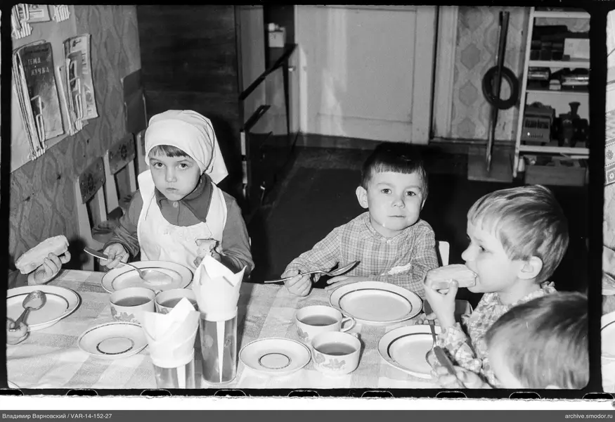 Kinder am Tisch mit Geschirr