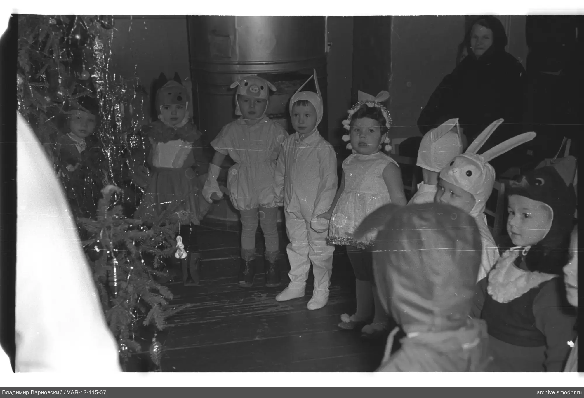 Kinder in Kostümen bei Weihnachtsbaum
