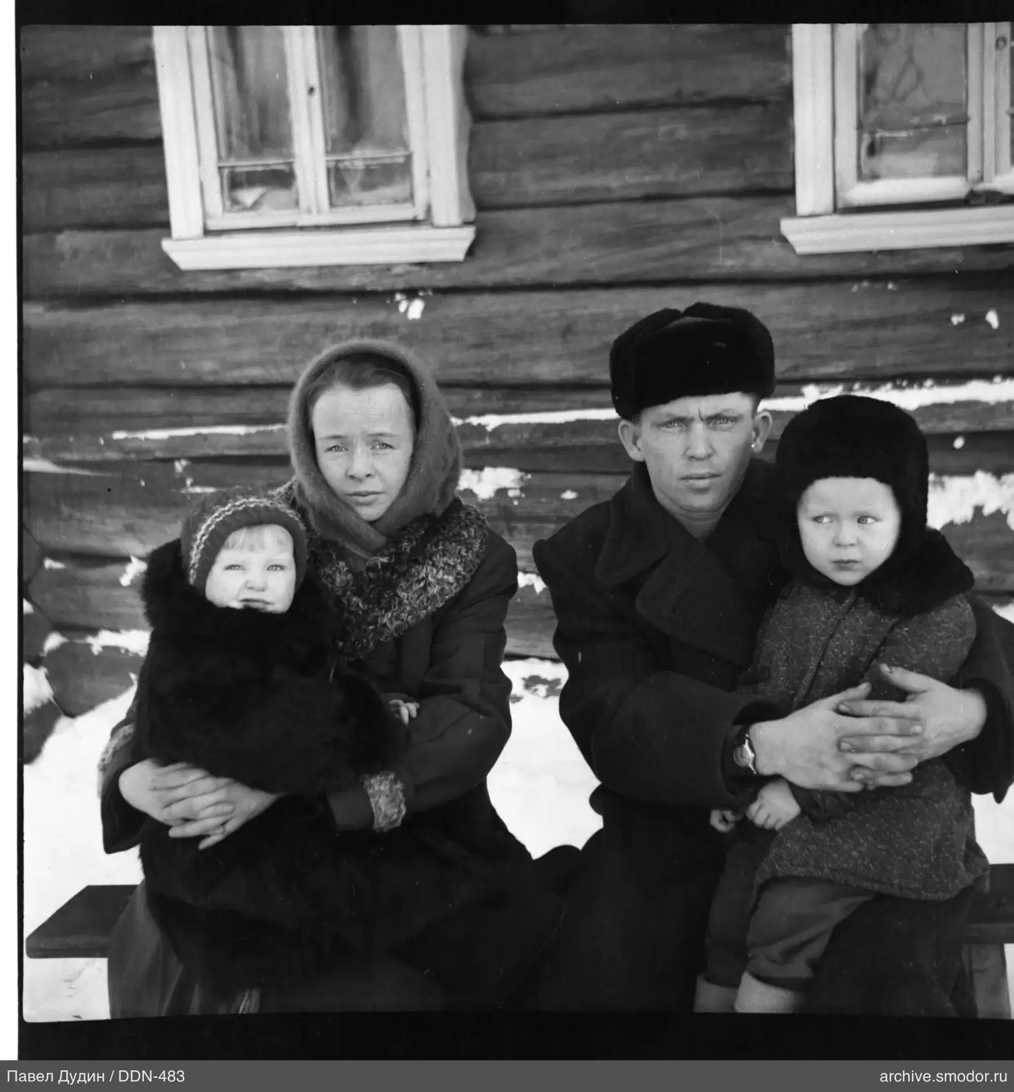 Группа на скамейке у деревянного дома