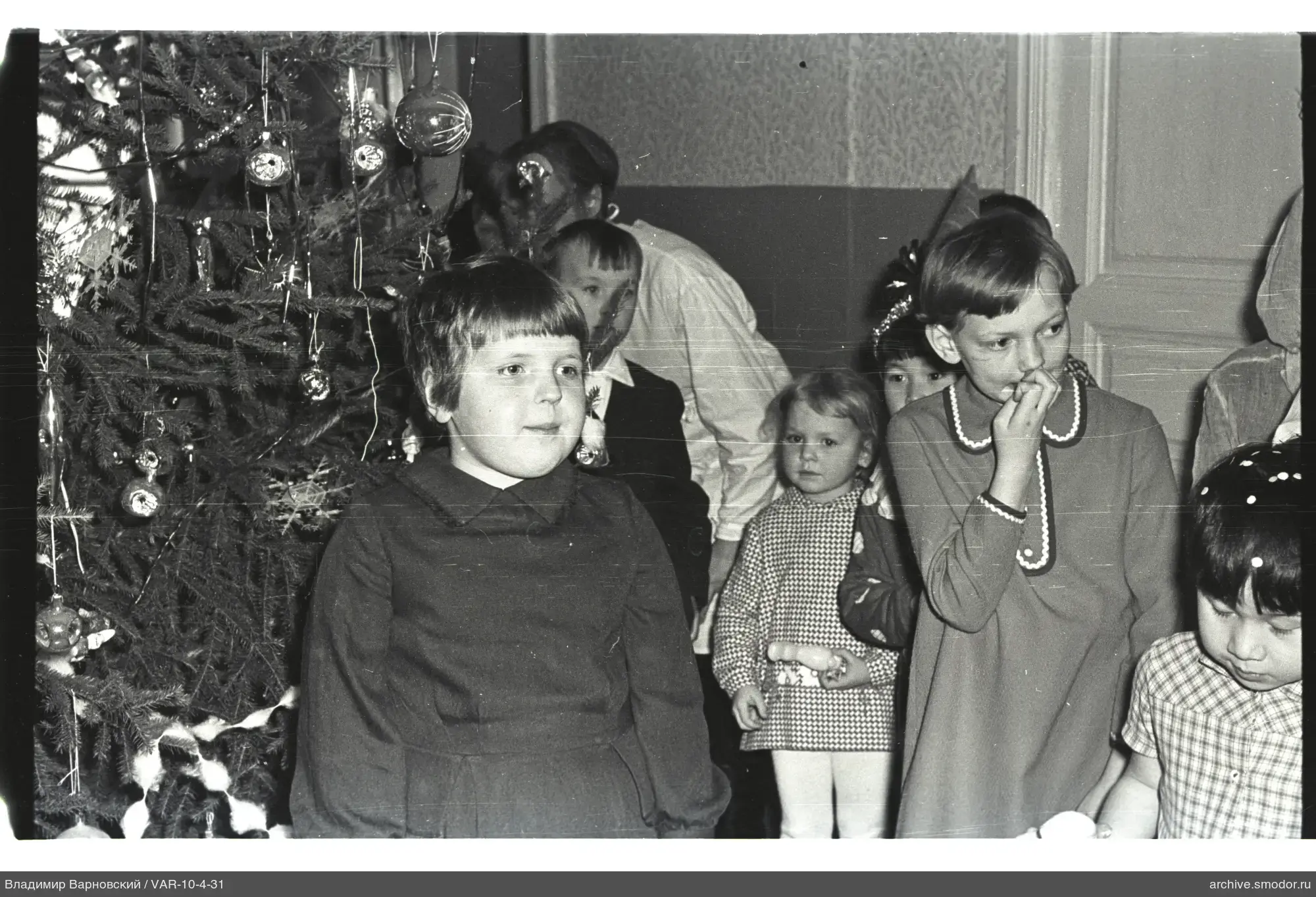 Kinder bei geschmücktem Weihnachtsbaum