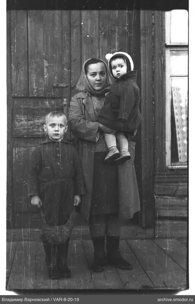 Gruppe mit Frau und Kindern bei Holztür