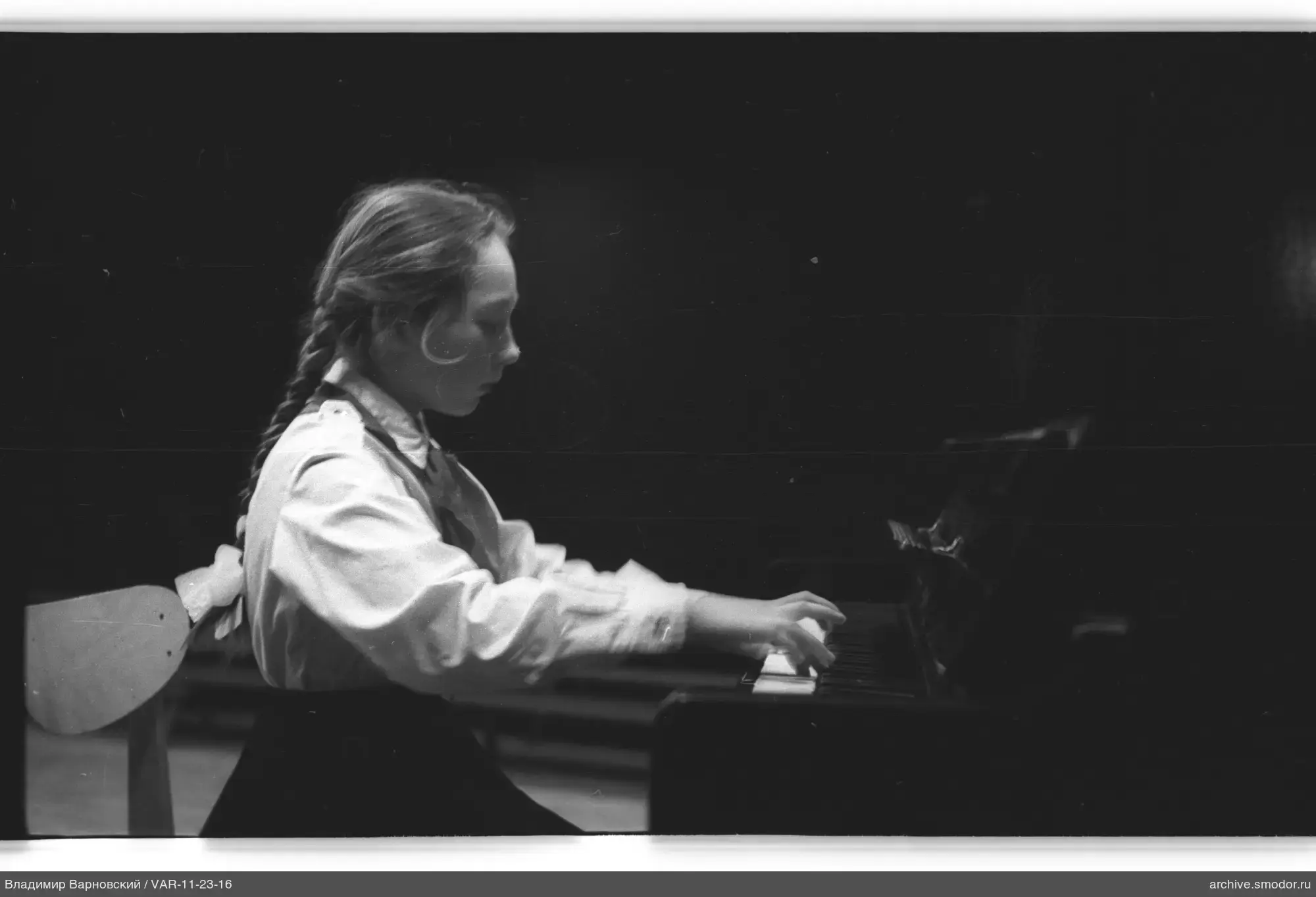 Girl at a grand piano in profile