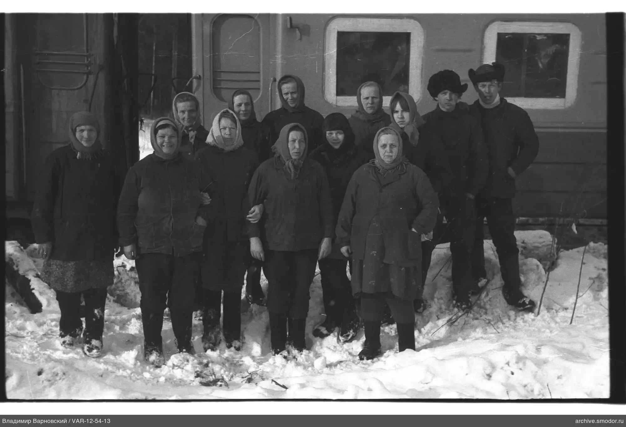 Gruppe von Menschen im Schnee bei einem Wagen