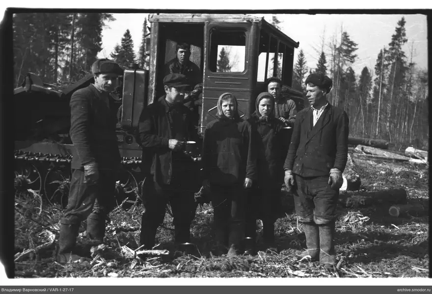 Группа людей у трактора на лесной поляне