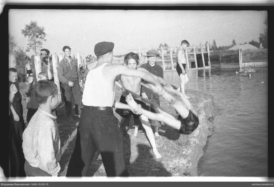 Mann hält Jungen kopfüber über Wasser