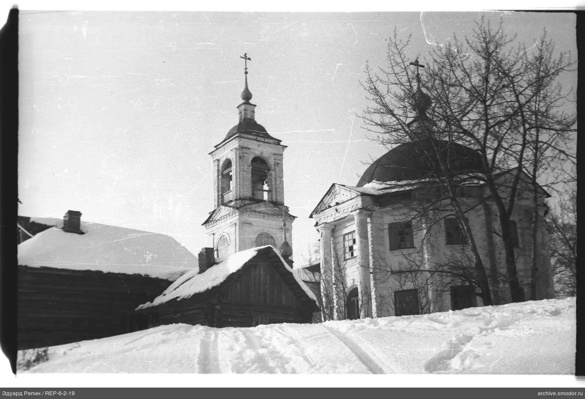 Schneebedeckter Hang und Steinkirche mit Kuppel