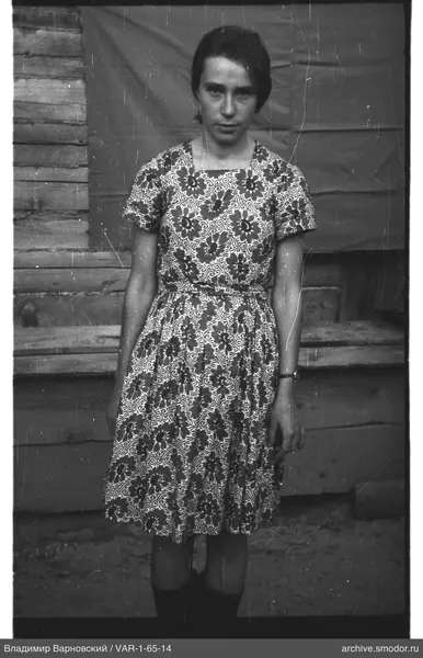 Woman in dress against wooden wall