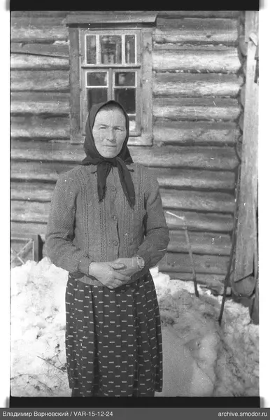 Frau vor einem Holzhaus