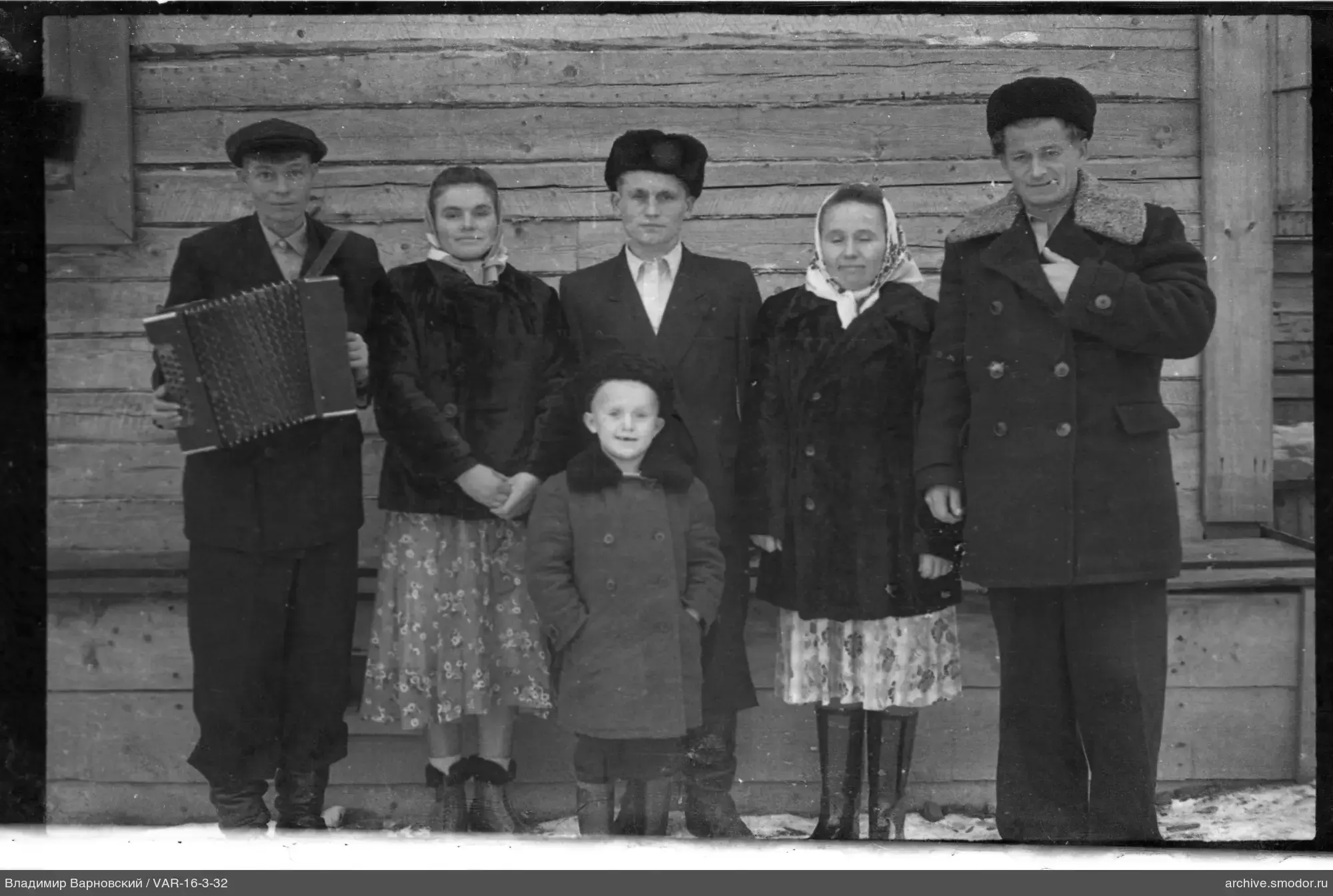 Gruppe von Menschen vor einem Holzhaus