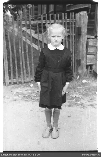 Mädchen in Kleid mit Schürze und Zöpfen