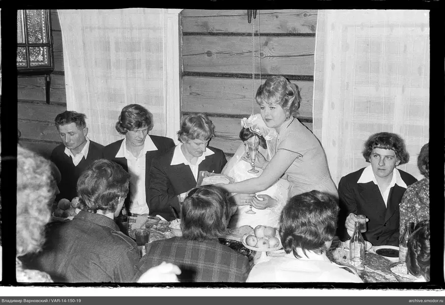 Gruppe am Tisch mit Frauen in hellen Kleidern