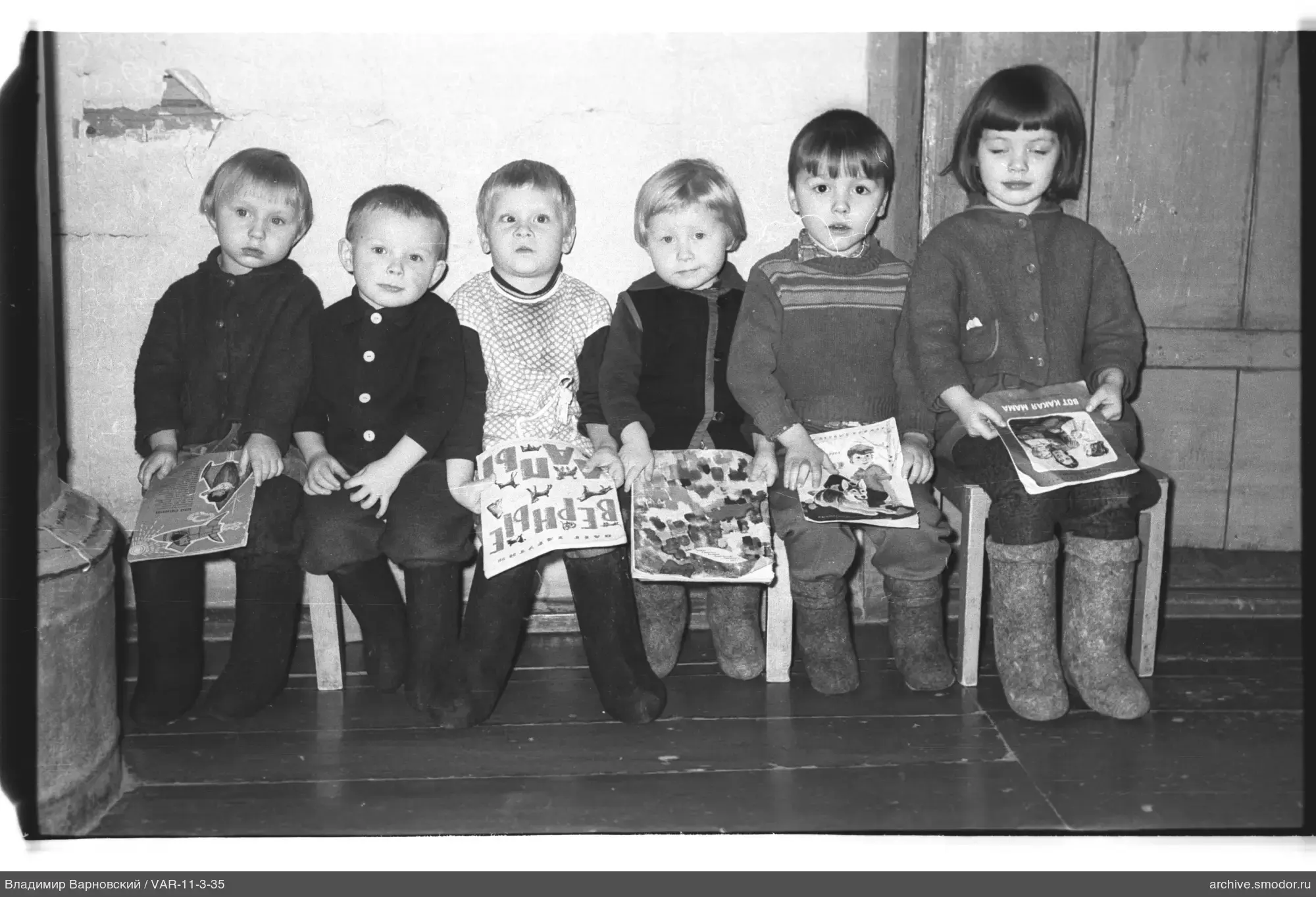 Group of children with books by the wall