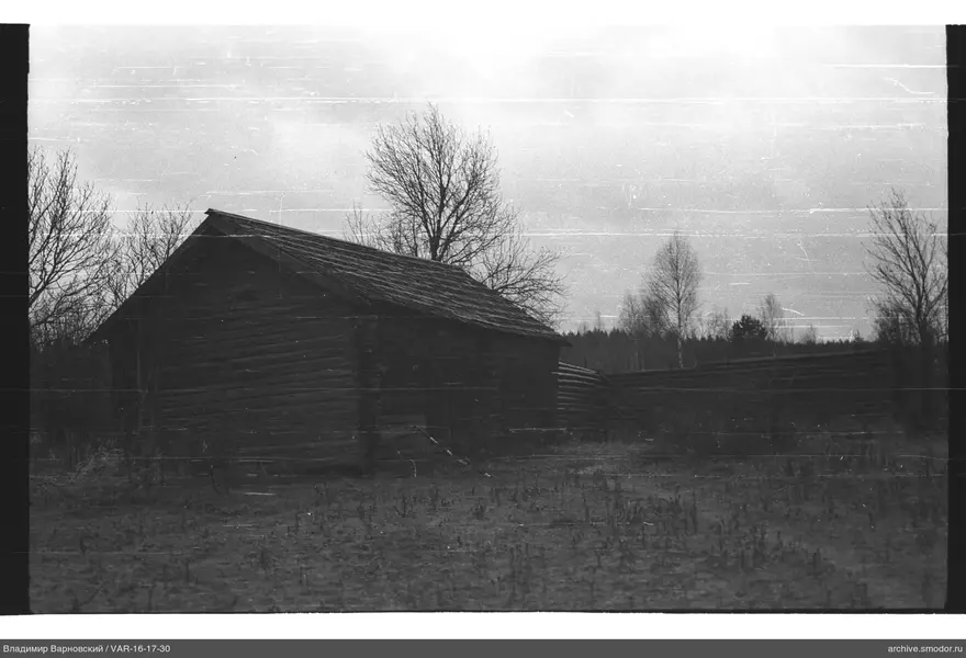 Holzblockhaus mit Zaun und Feld
