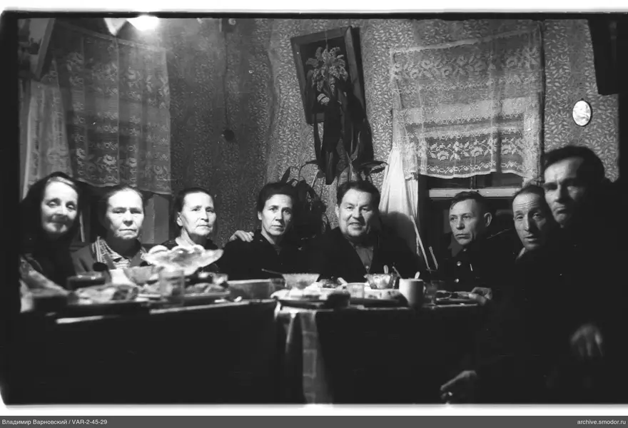 Group of people at a table with dishes and food
