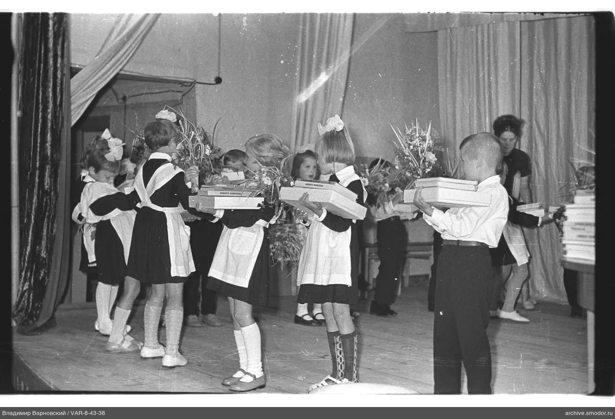 Kinder auf der Bühne mit Büchern und Blumen