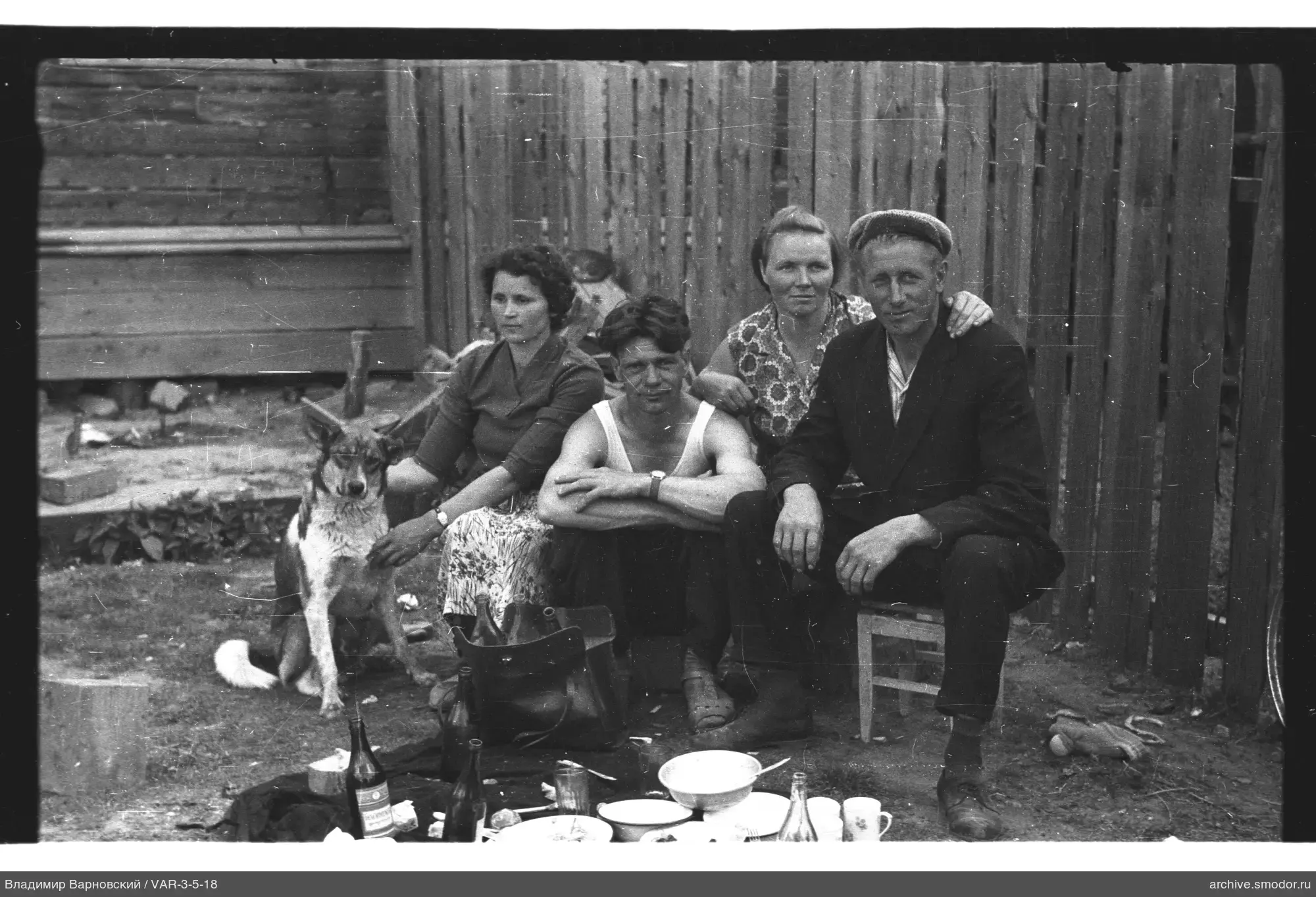 Gruppe mit Hund bei Holzzaun