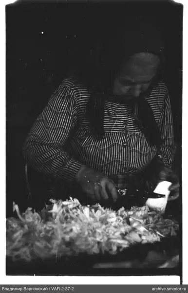 Woman with knife at table of chopped vegetables