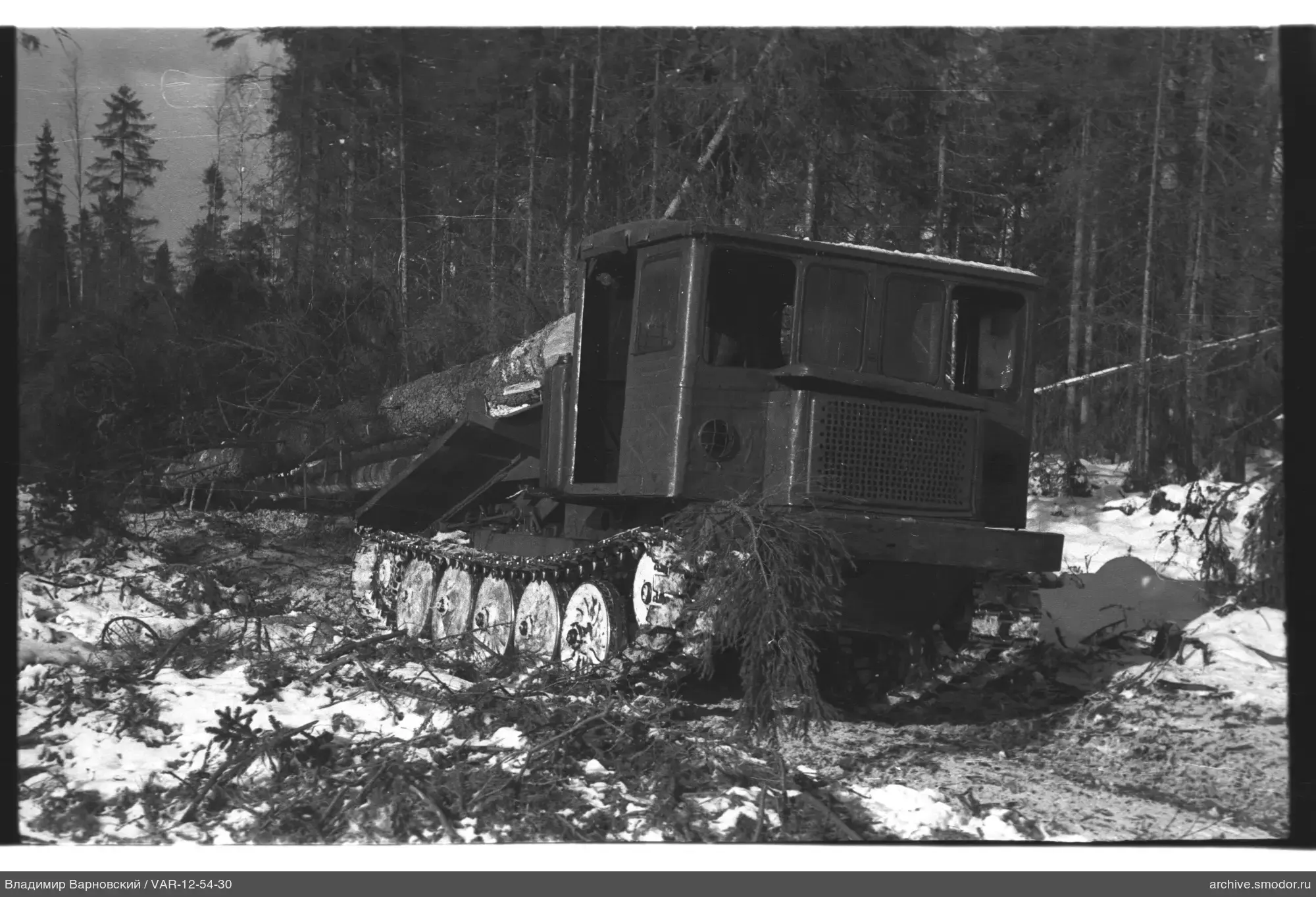 Kettentraktor auf verschneiter Waldlichtung