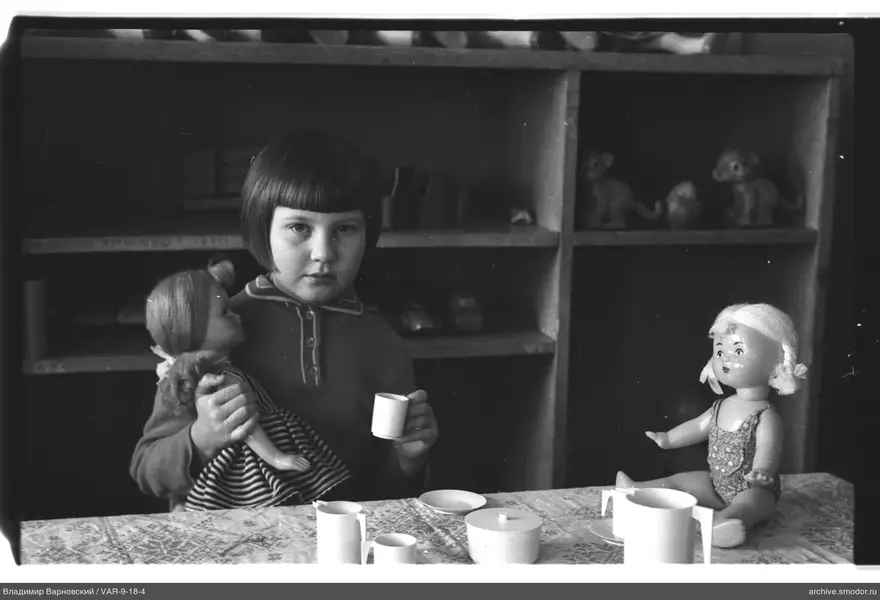 Child with dolls and tea set