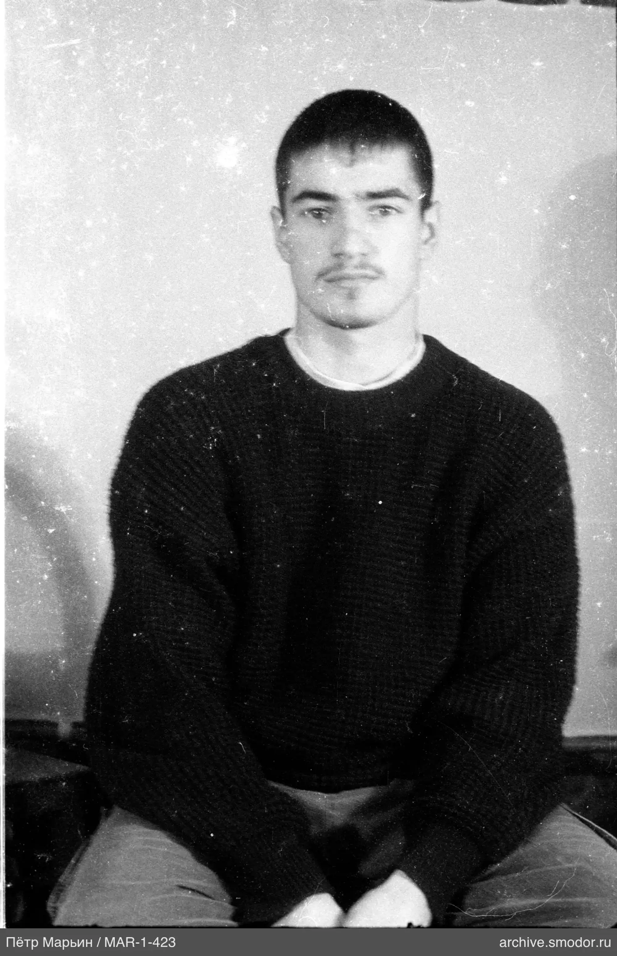 Mann in Strickpullover und hellen Hosen