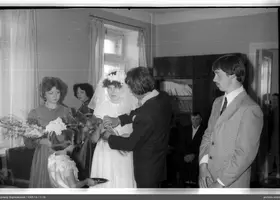Man placing something in bride's hand