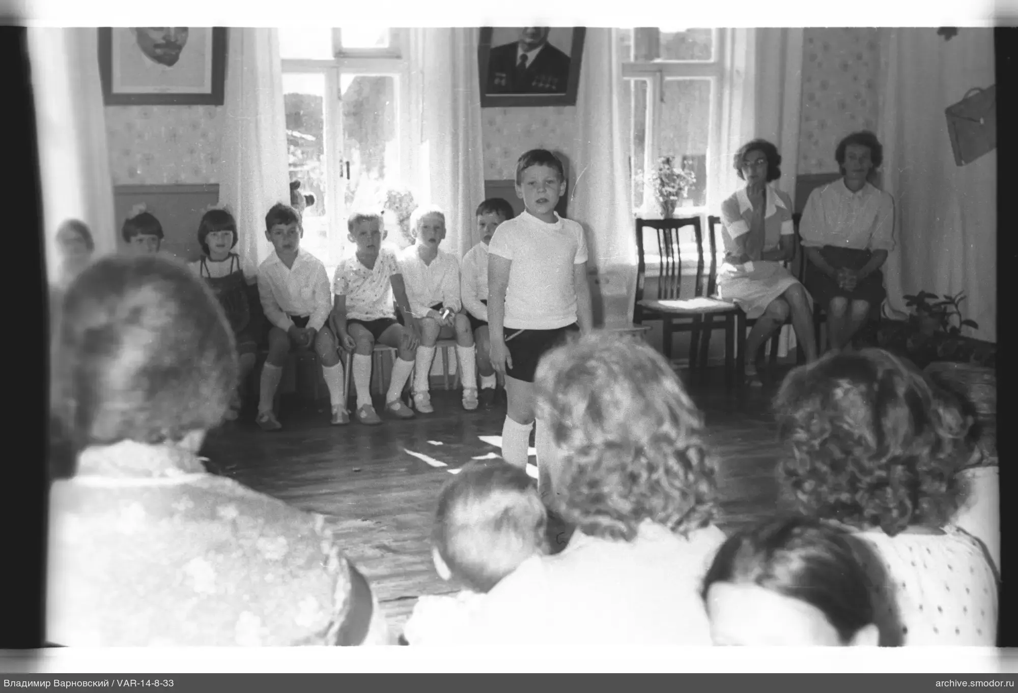 Junge in weißem T-Shirt mit Kindern im Raum